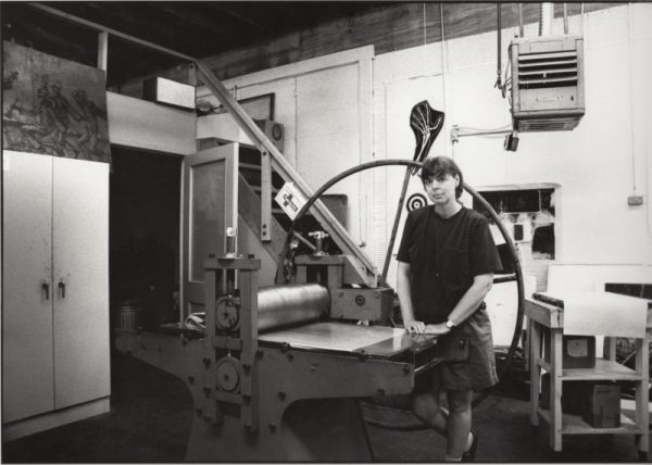 Katherine standing behind a press in the press room of the first building