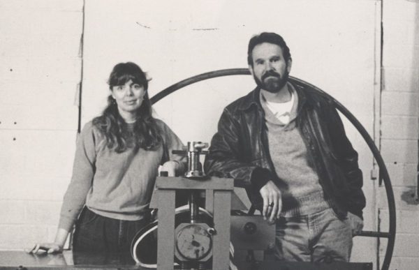 Katherine Brimberry and Mark Smith standing behind etching press