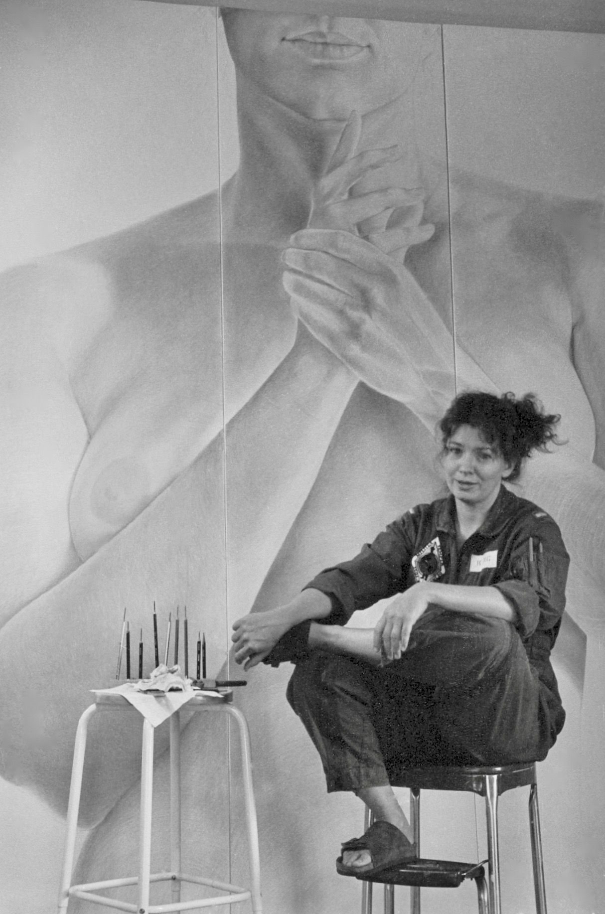 Image of the artist in front of a large figure drawing