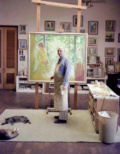 Artist painting in his studio with cat and dog