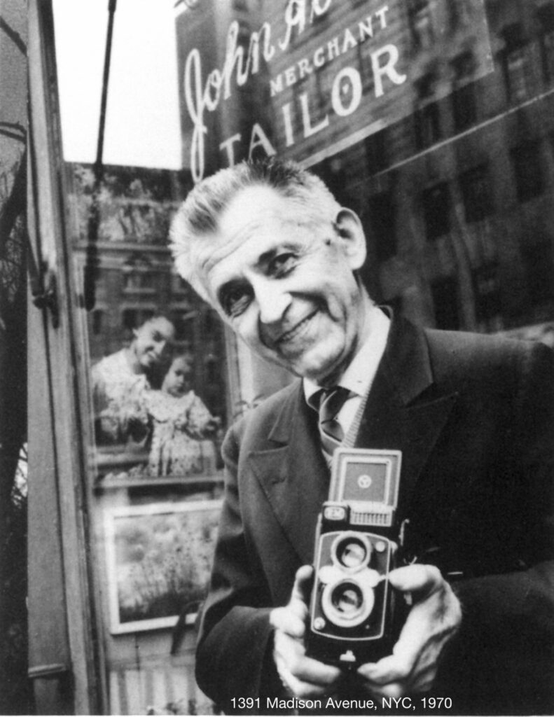 Albok Holding Camera outside his shop.